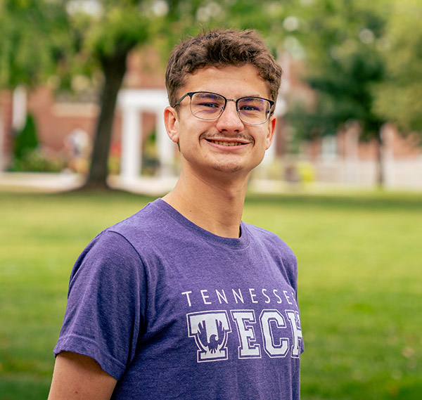 Drew Ewers posting on the Main Quad, looking at the camera.