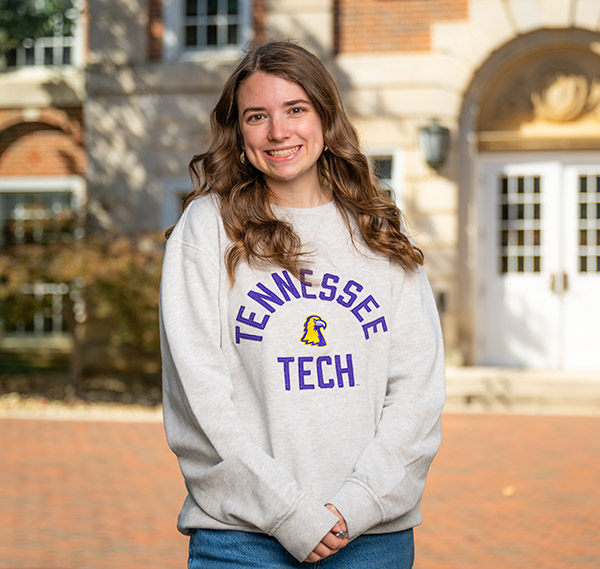 Addison Johnson holding soccer ball and computer.