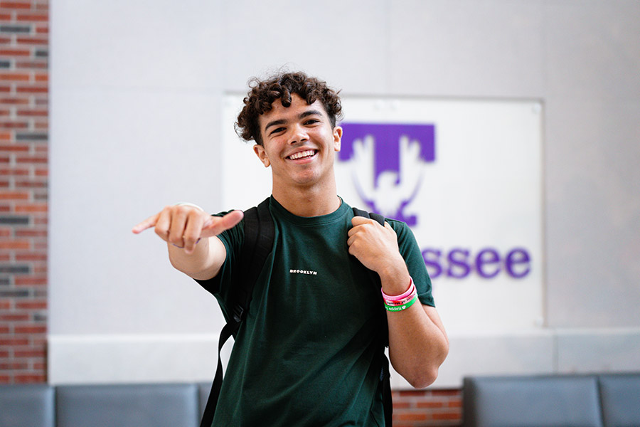 A student posting for the camera giving a Wings Up hand gesture.