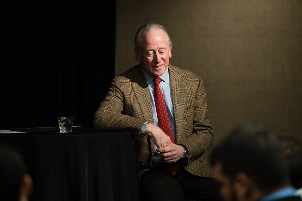 Archie Manning sits at a table and speaks to an audience.