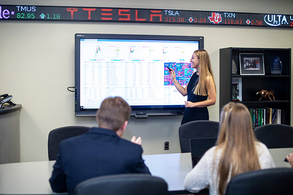 A student standing in front of a class giving a presentation.