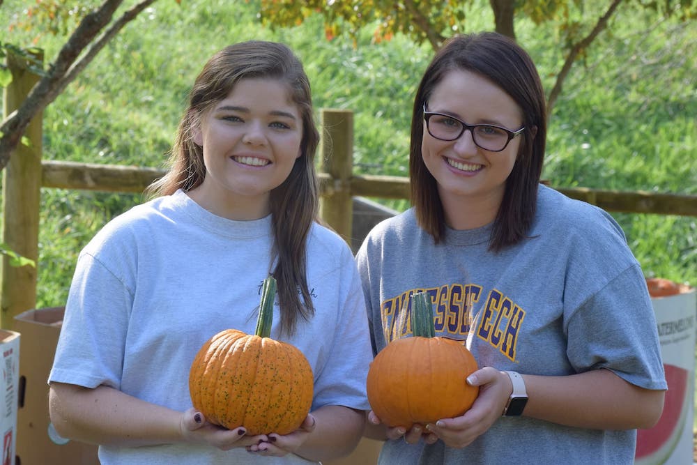 Students pass out pumpkins at the annual fall festival