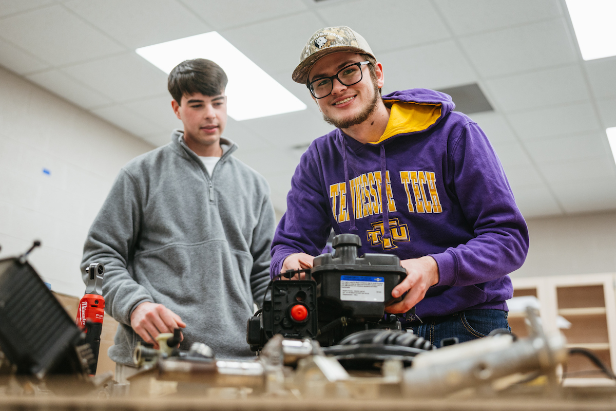 Two Tennessee Tech students work together on a small engine during a hands-on lab.