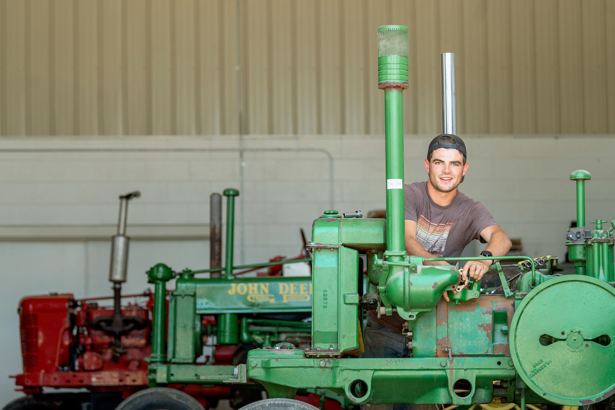 Male student works on an old John Deere tractor