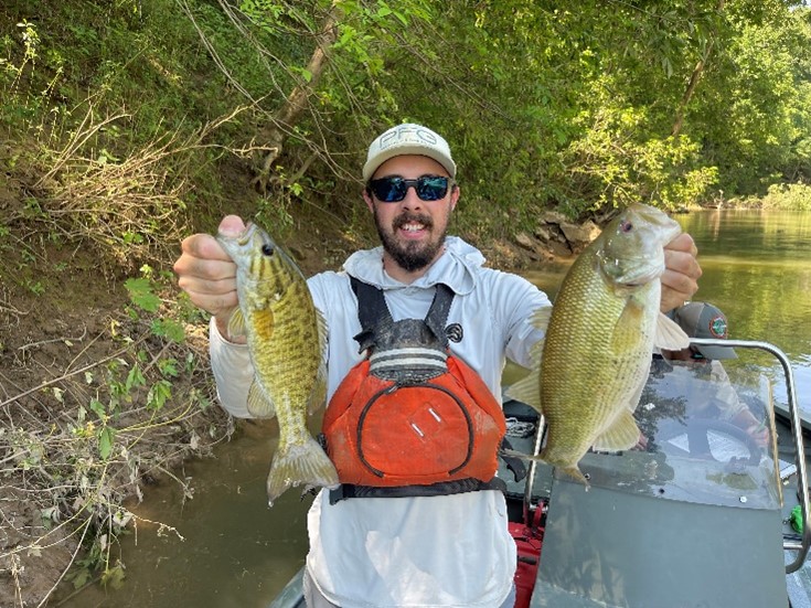 Thomas Miles holding two fish