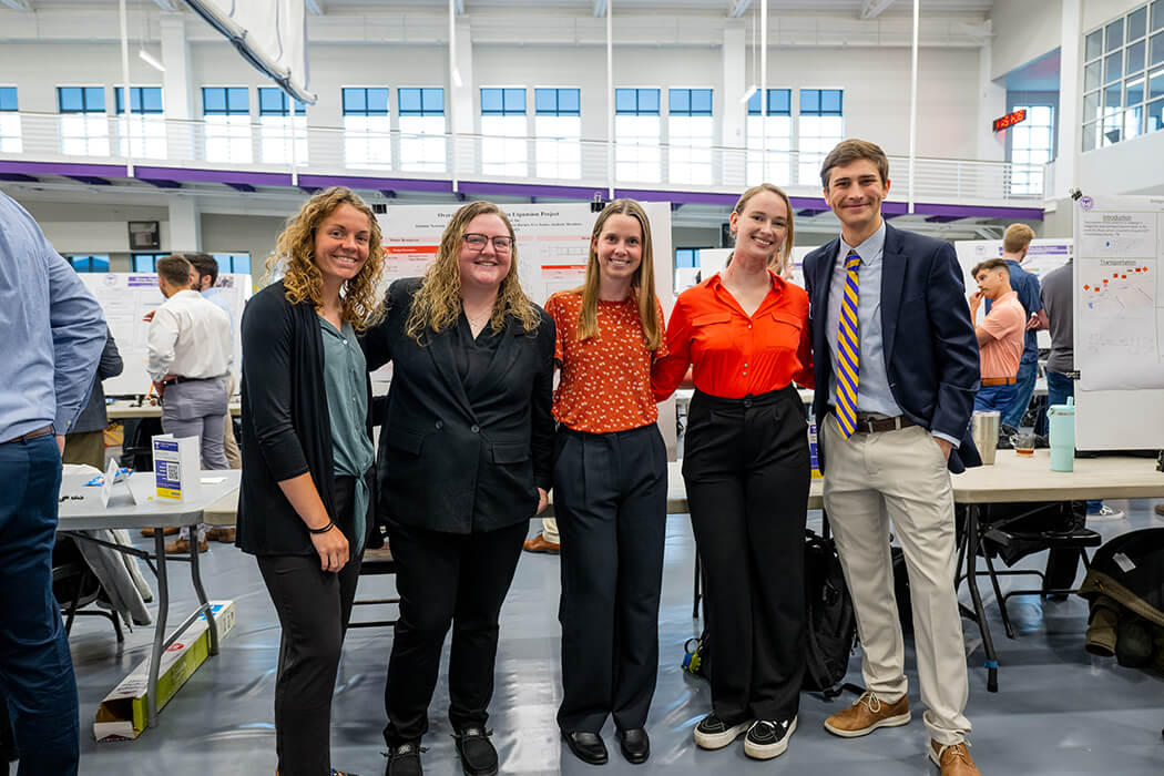 A photo of team of 5 students presenting their capstone project