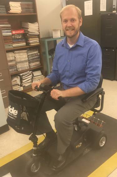 Dr. Charles Van Neste on a wirelessly charged scooter