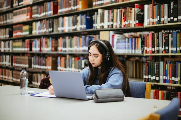 Student with computer in library