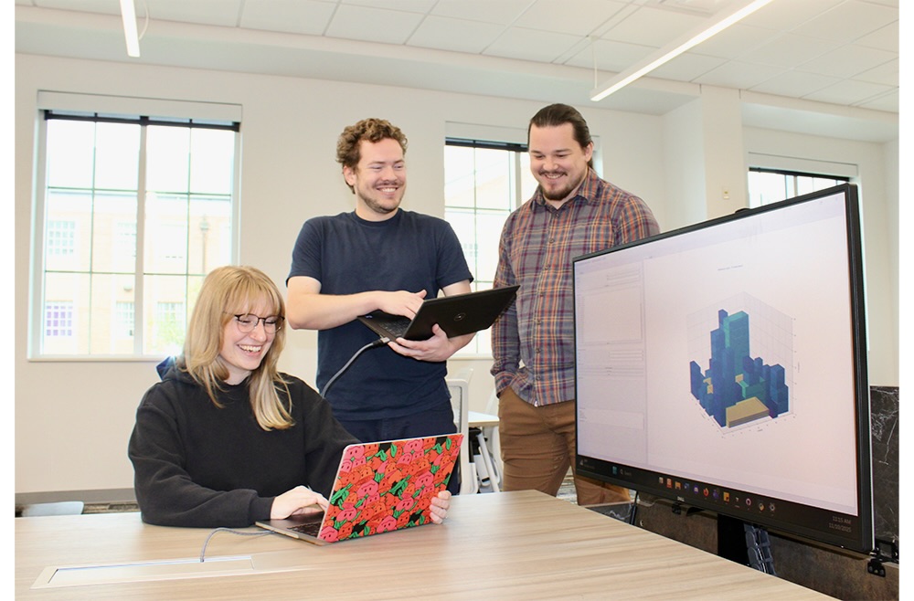 Students gather around a computer working on an AI project