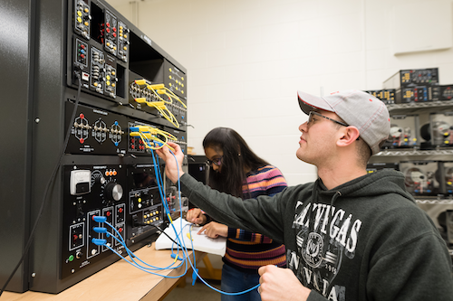 Students operate computer engineering equipment
