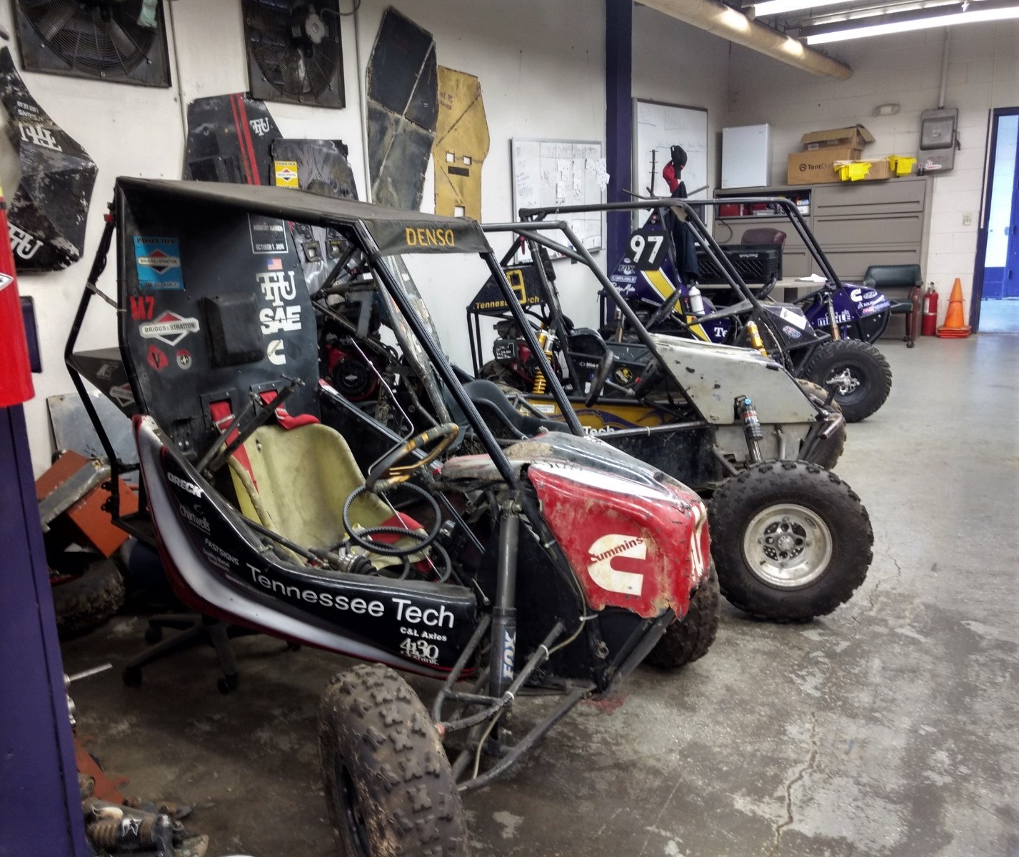 Four Baja SAE cars lined up against a wall