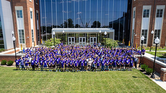 Photo of College of Engineering 2025 freshman class standing on terrace of Ashraf Islam Engineering Building