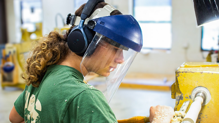A student at a wood carving machine.