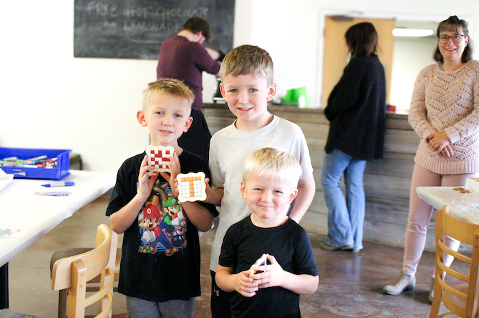 three boys posing with their crafts