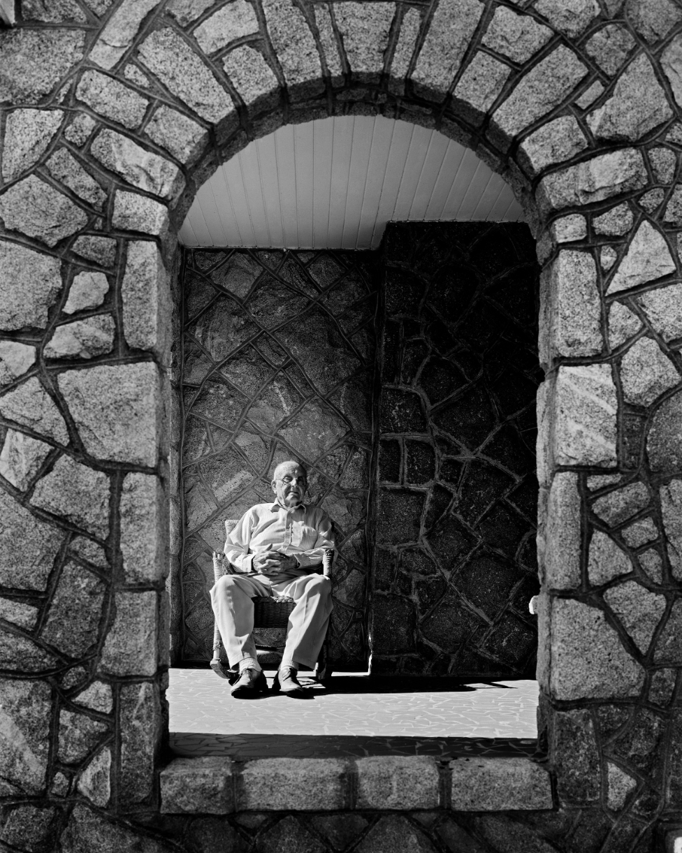 Black and white photo of man sitting in a chair
