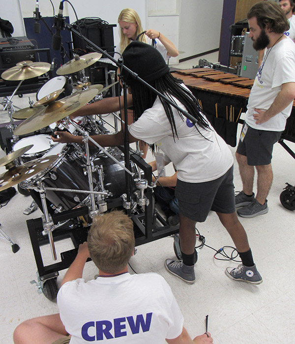 A group of Live Audio crew wiring a drum set for sound.