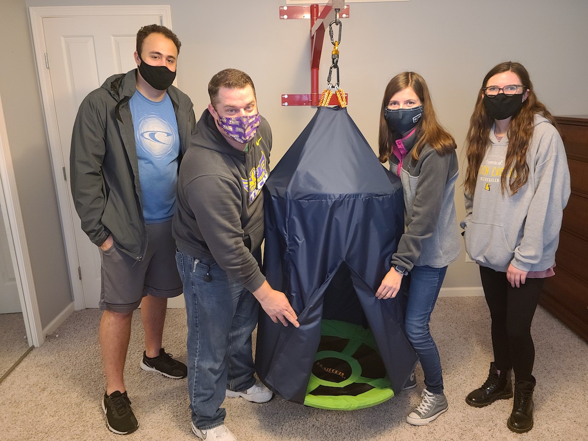 Tennessee Tech mechanical engineering students (from left) Gabriel DaSilva, John Wagner, Emily Carroll and Lexie Carrier installed a sensory swing they built for an autistic child.