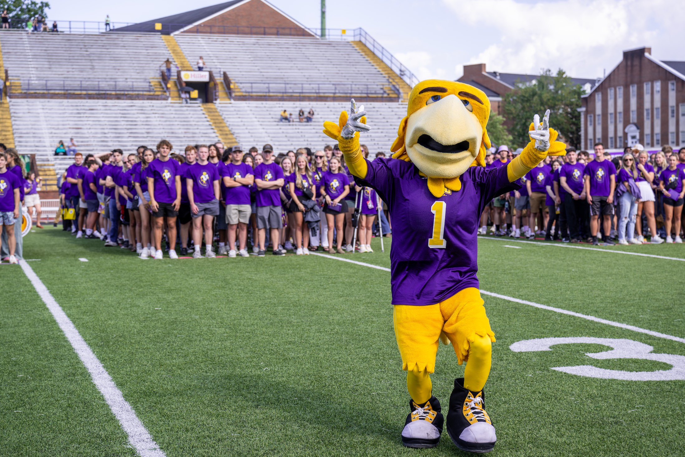 Awesome Eagle helps assemble students for the annual class photo on the football field following convocation.