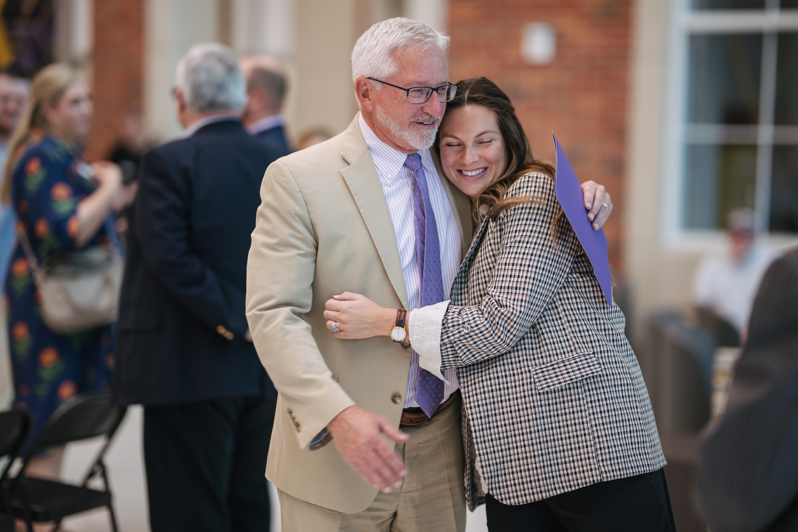 Kendall Vaughn Phillips smiles as she gives a hug to Tech President Phil Oldham