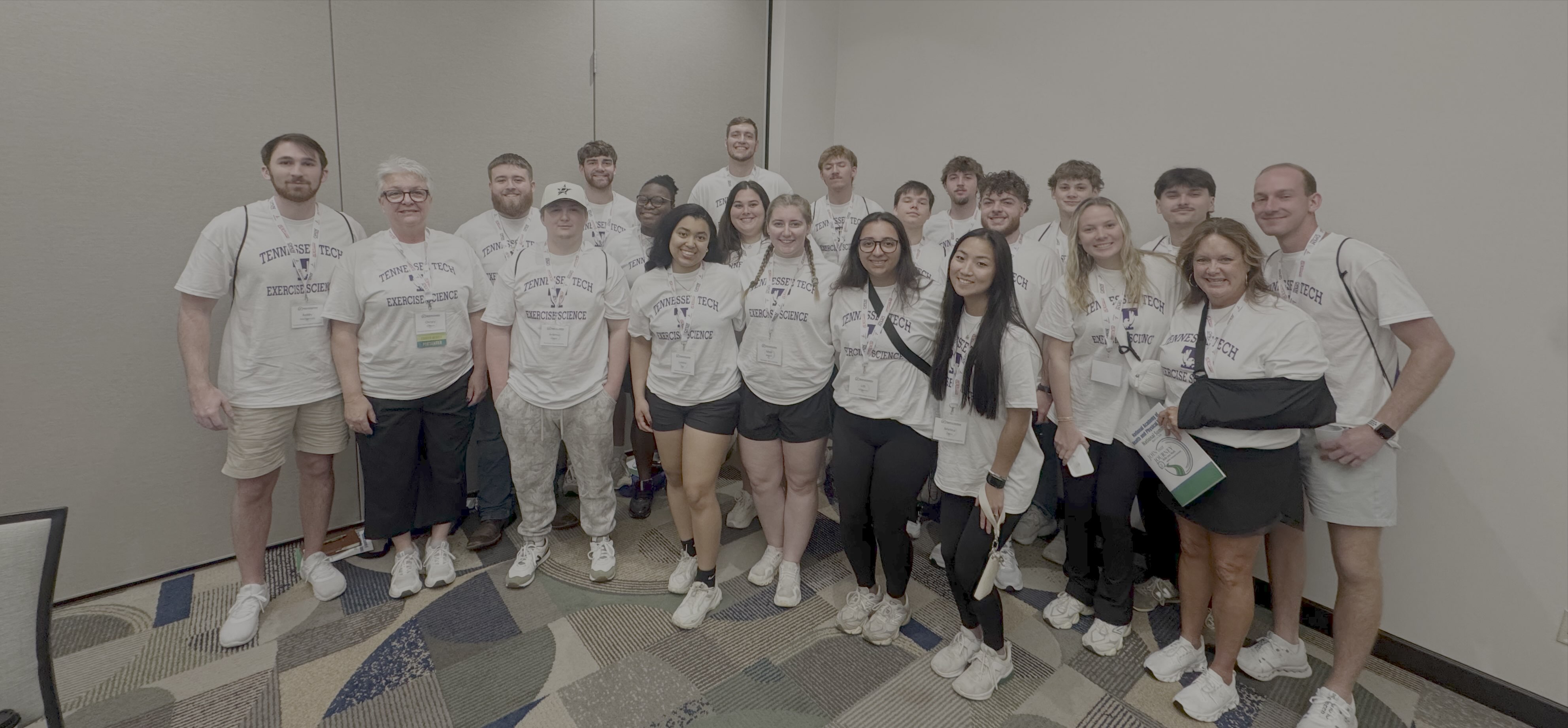 Group photo of students in Tennessee Tech t-shirts against a blank wall. 