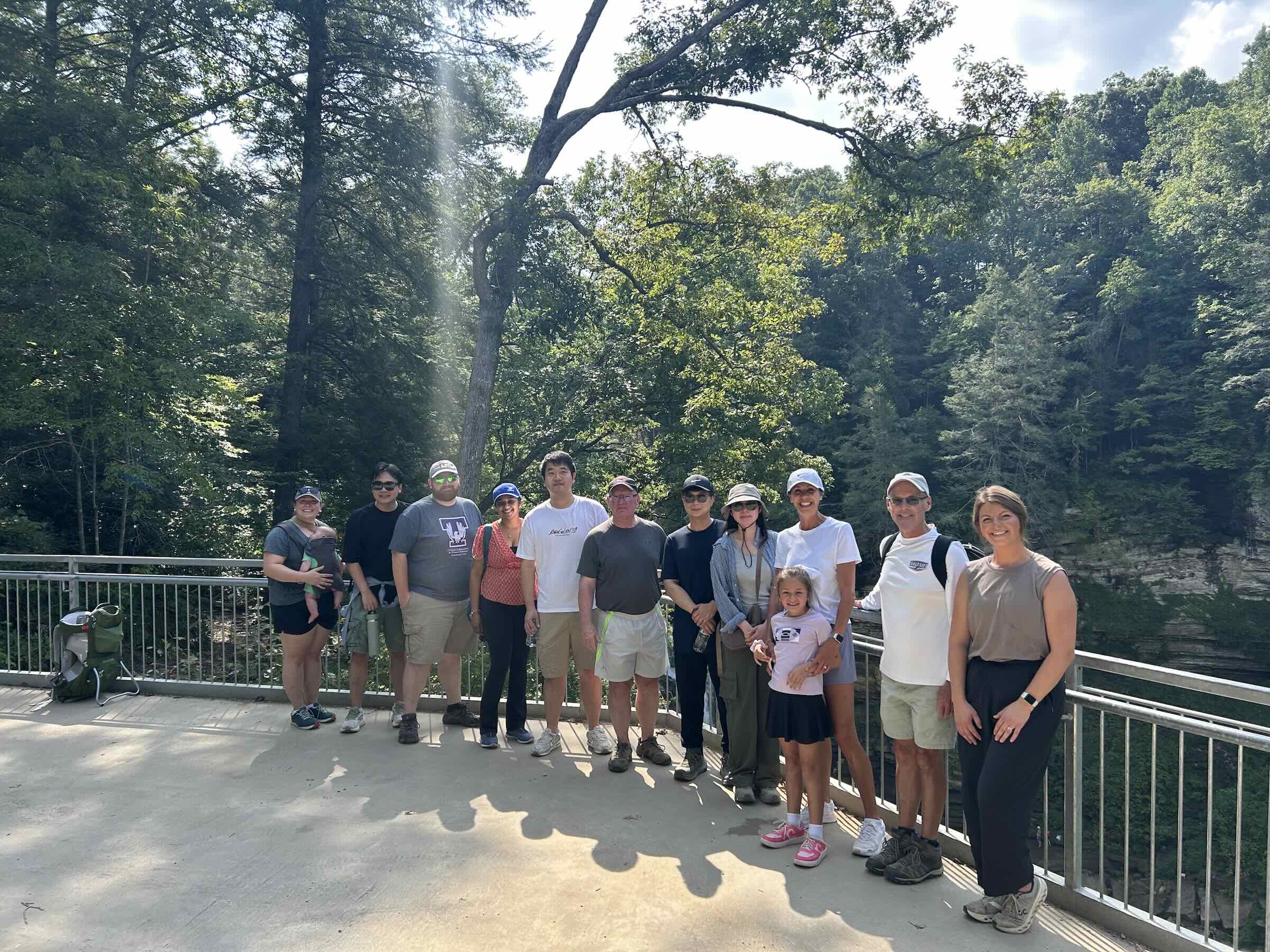 Mickey Latour is shown at a scenic overlook in a wooded area with a crowd of people.