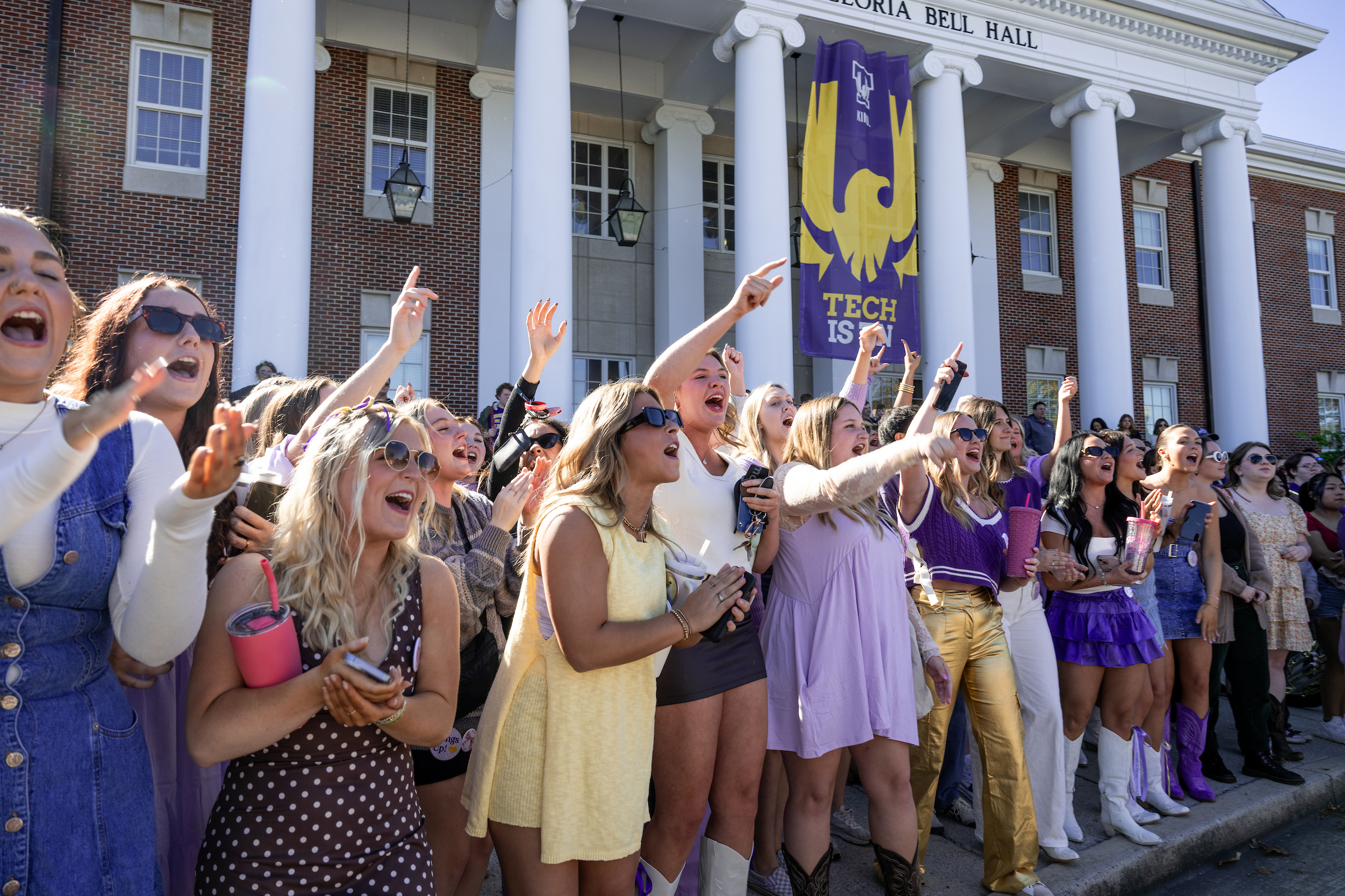 students cheering in front of Bell Hall during the Homecoming Parade