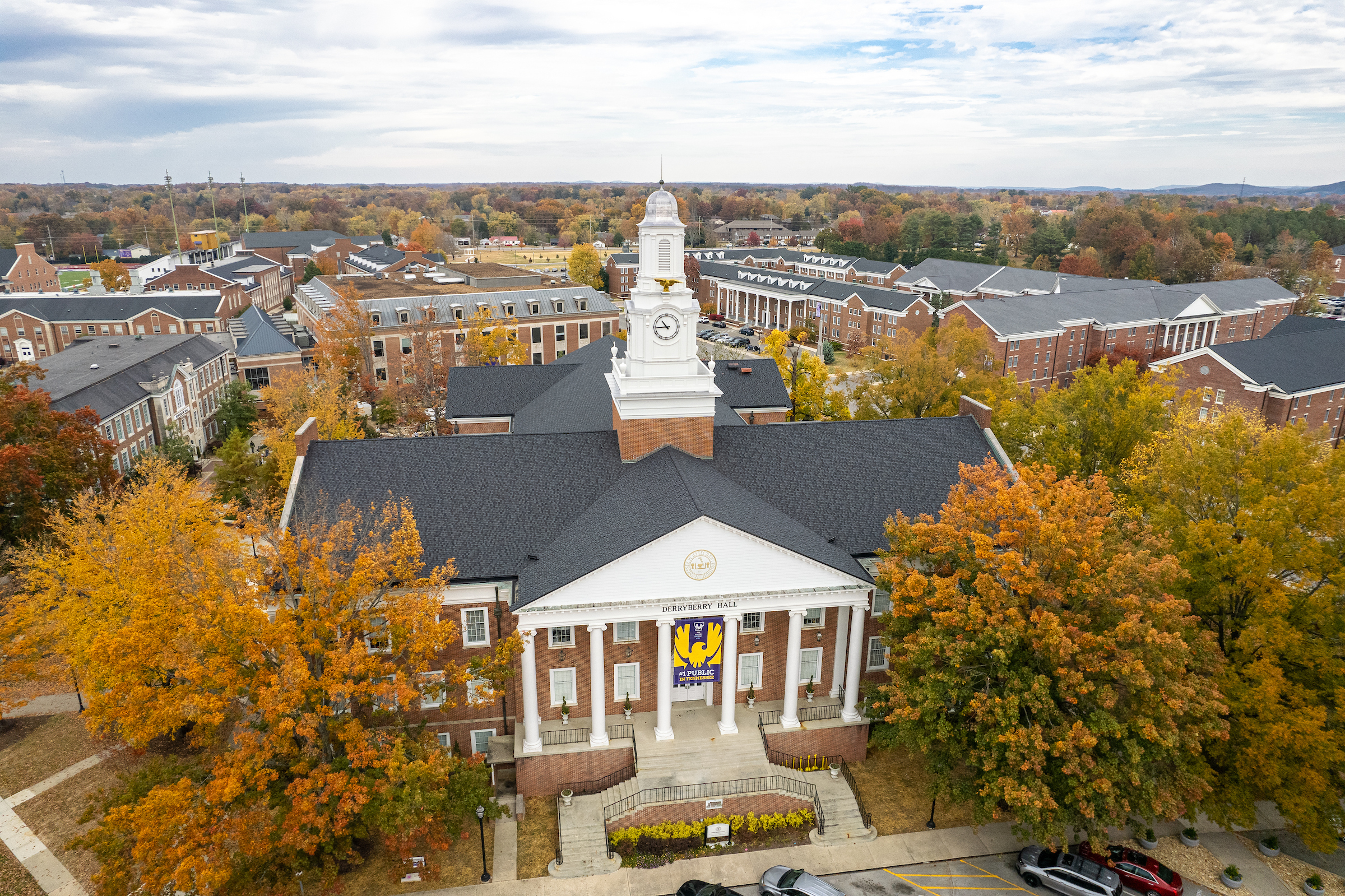An aerial view of Derryberry Hall during fall, with orange-red foliage on the nearby trees