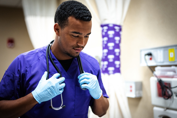 Nurse holds stethescope and looks downward