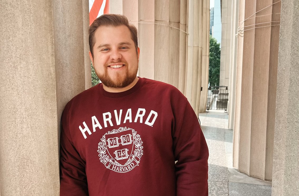 Aaron Thomas Lay wears a red Harvard sweatshirt