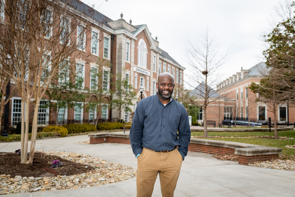 Dee Prince stands in front of Henderson Hall