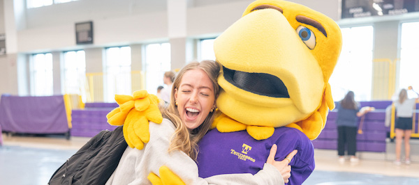 A student hugs Awesome Eagle