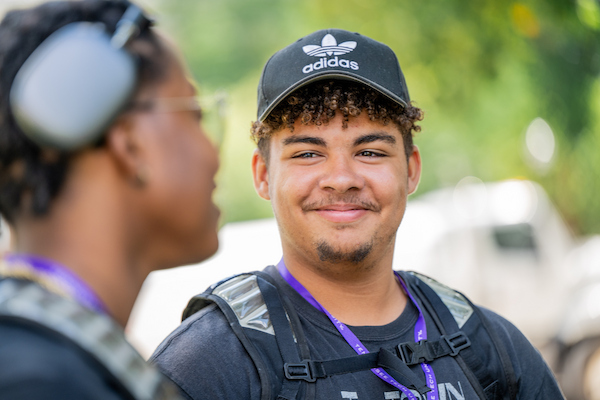 Image of a male student smiling at a friend sitting next to him