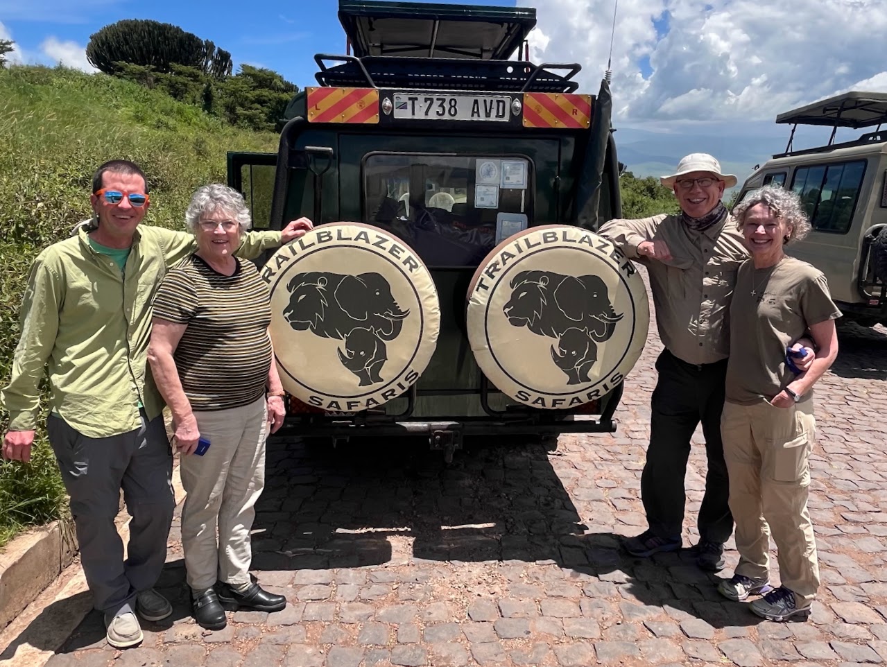 Alumni stand with the safari jeep