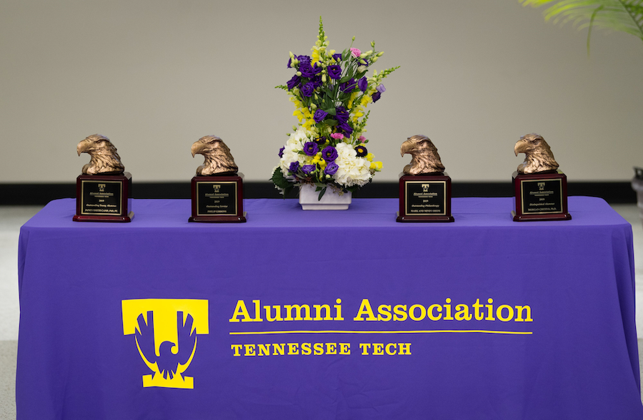A table with an Alumni Association table cloth and alumni awards