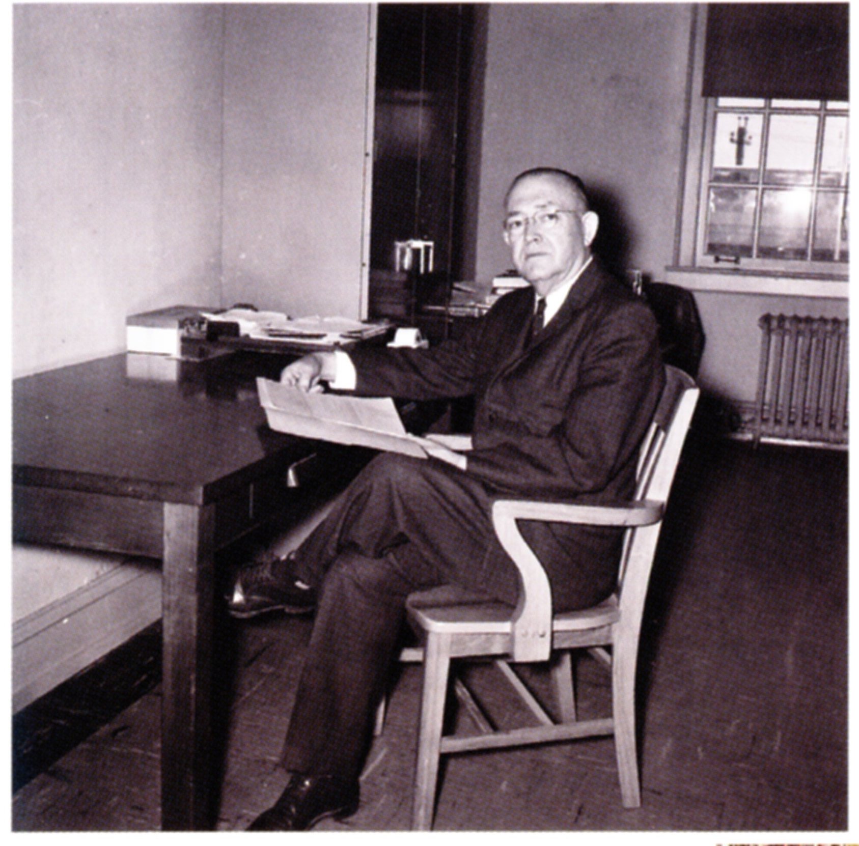 TJ Farr sitting as his desk in a black and white photo