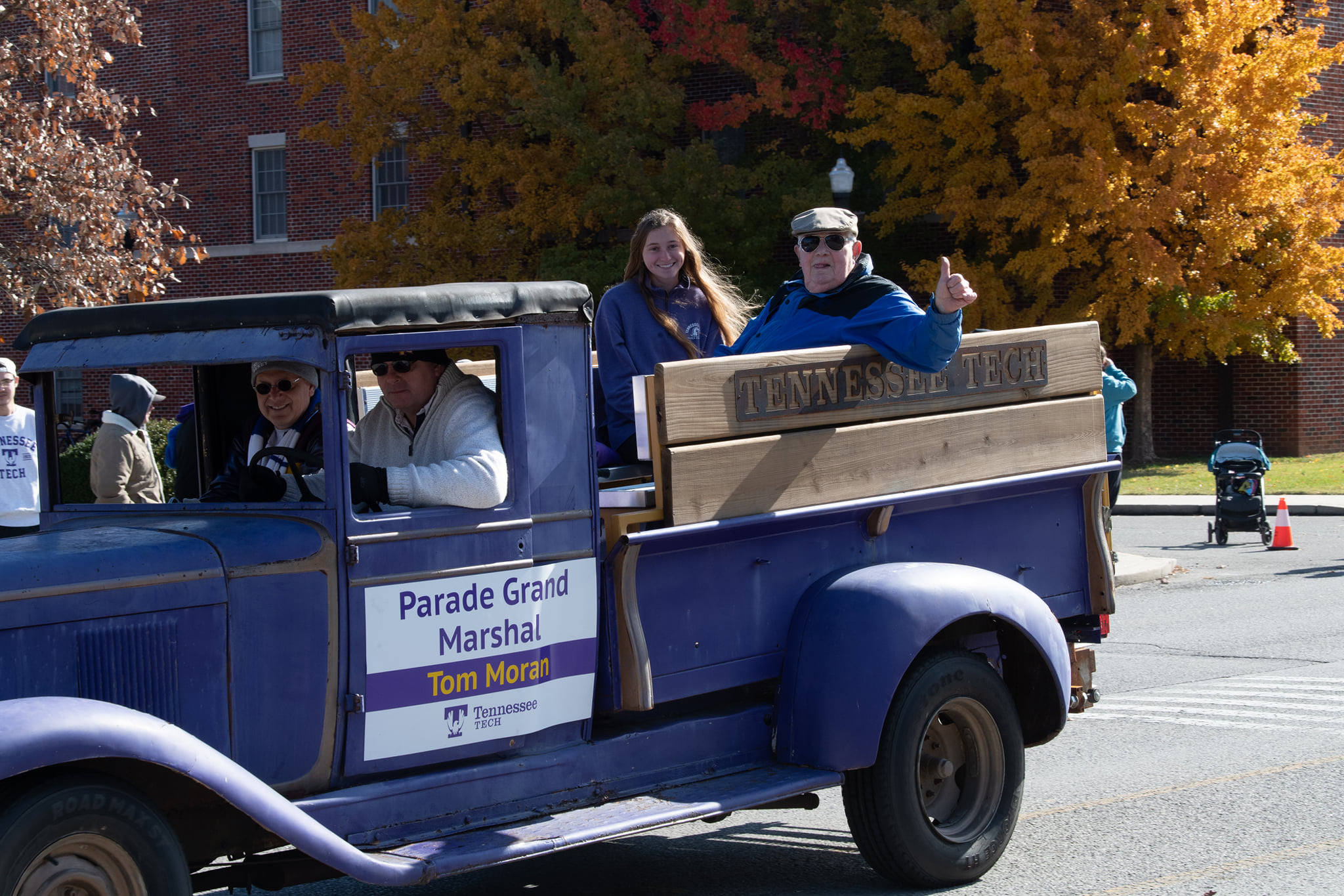 Tom Moran and his granddaugther ride in the bed of the Pep Truck in the 2021 Homecoming parade.