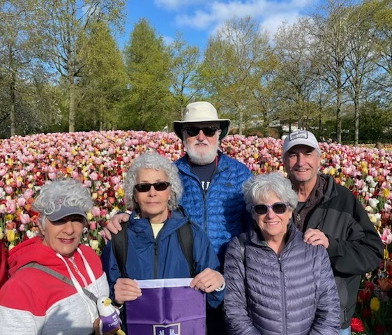 5 people standing in front of flower field smiling